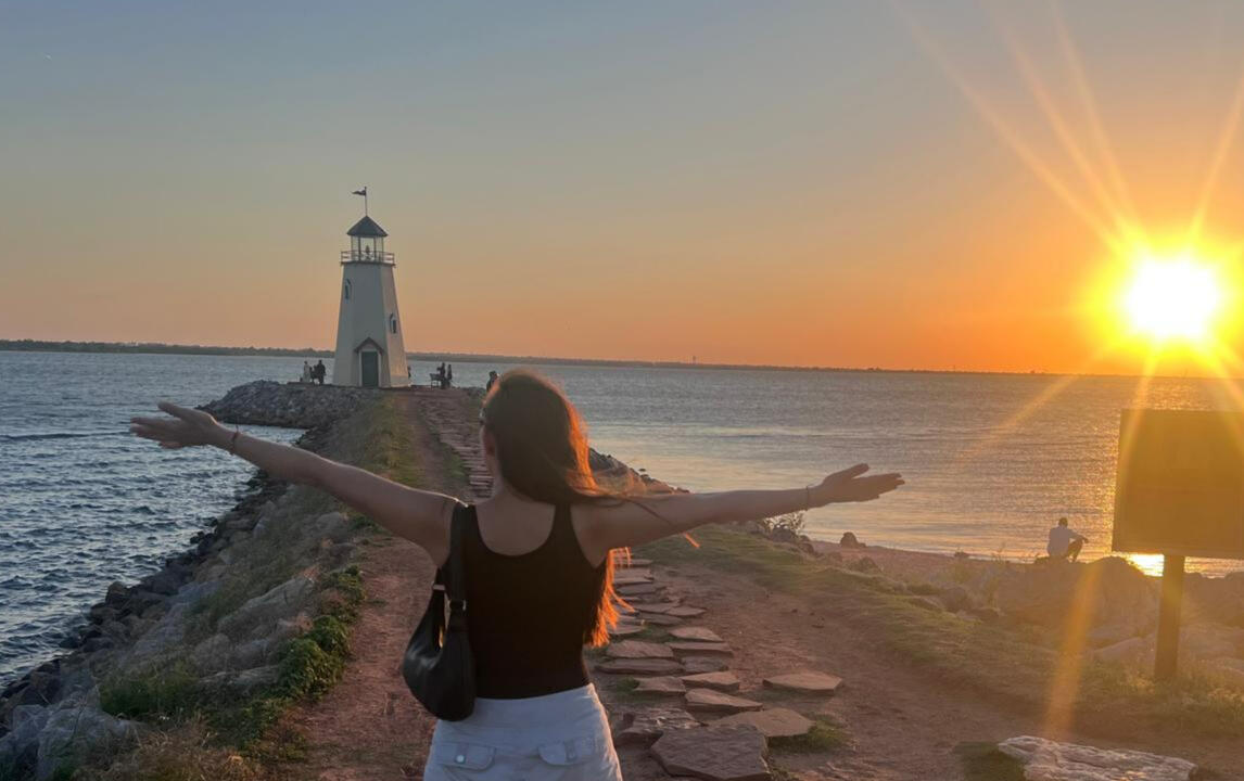Trabajando la gratitud Mujer con brazos abiertos agradeciendo al sol y la vida
